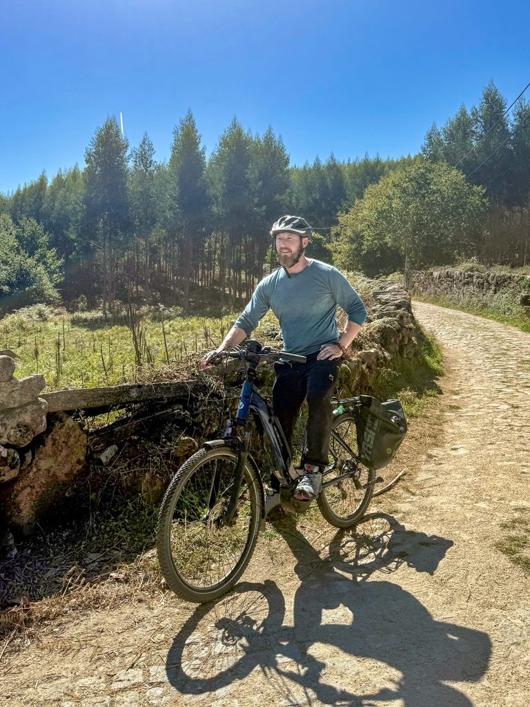 Heiko Lackstetter fährt mit dem Fahrrad über einen Waldweg des Jakobswegs.