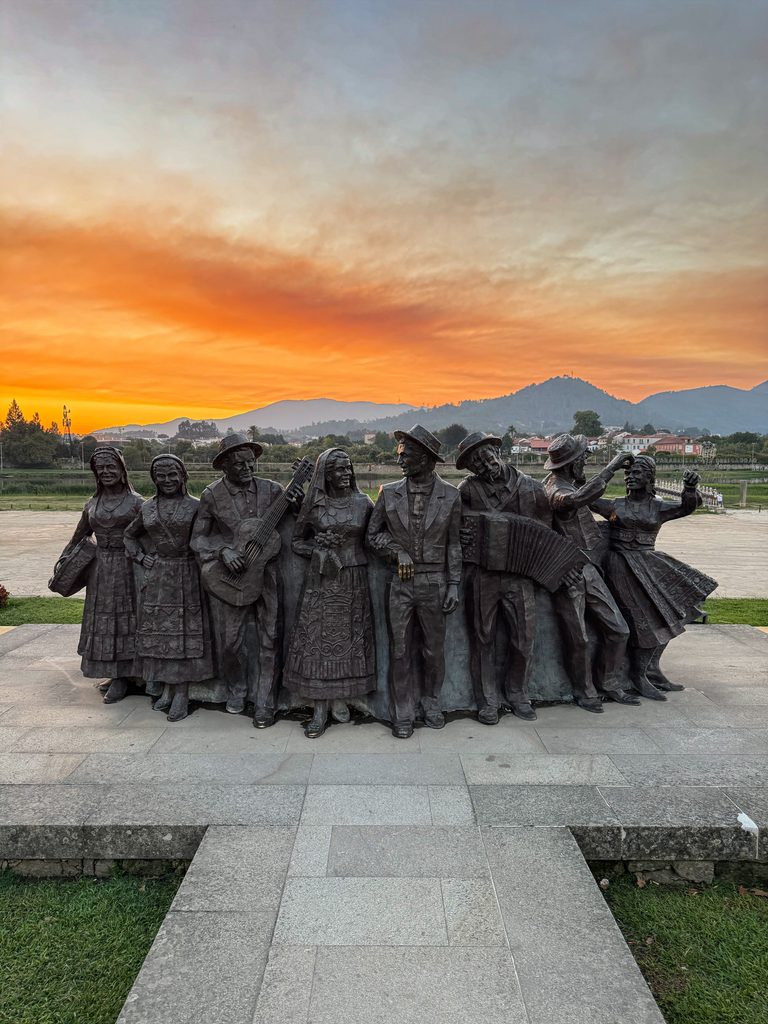 Pilgerdenkmal vor einem orangefarbenen Abendhimmel am Jakobsweg.